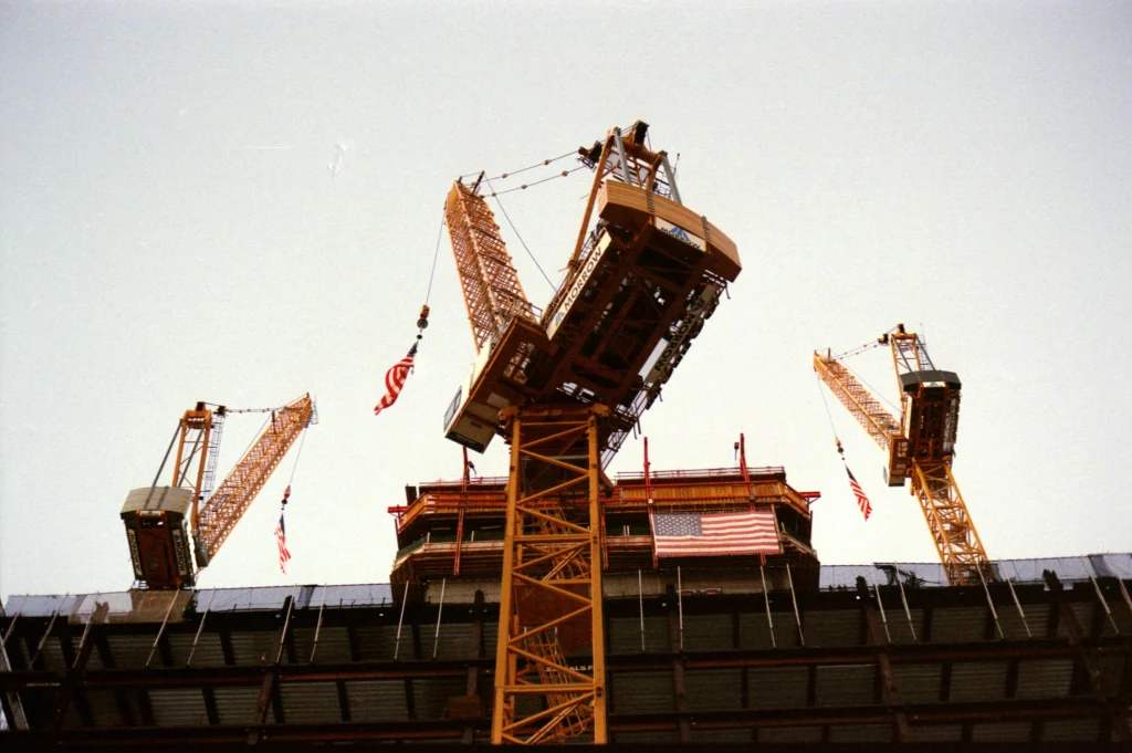 A view of underneath 3 tv cranes