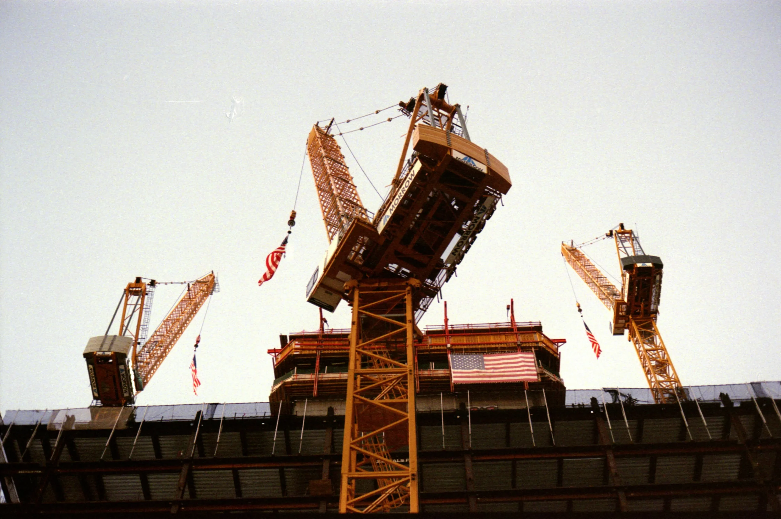 A view of underneath 3 tv cranes